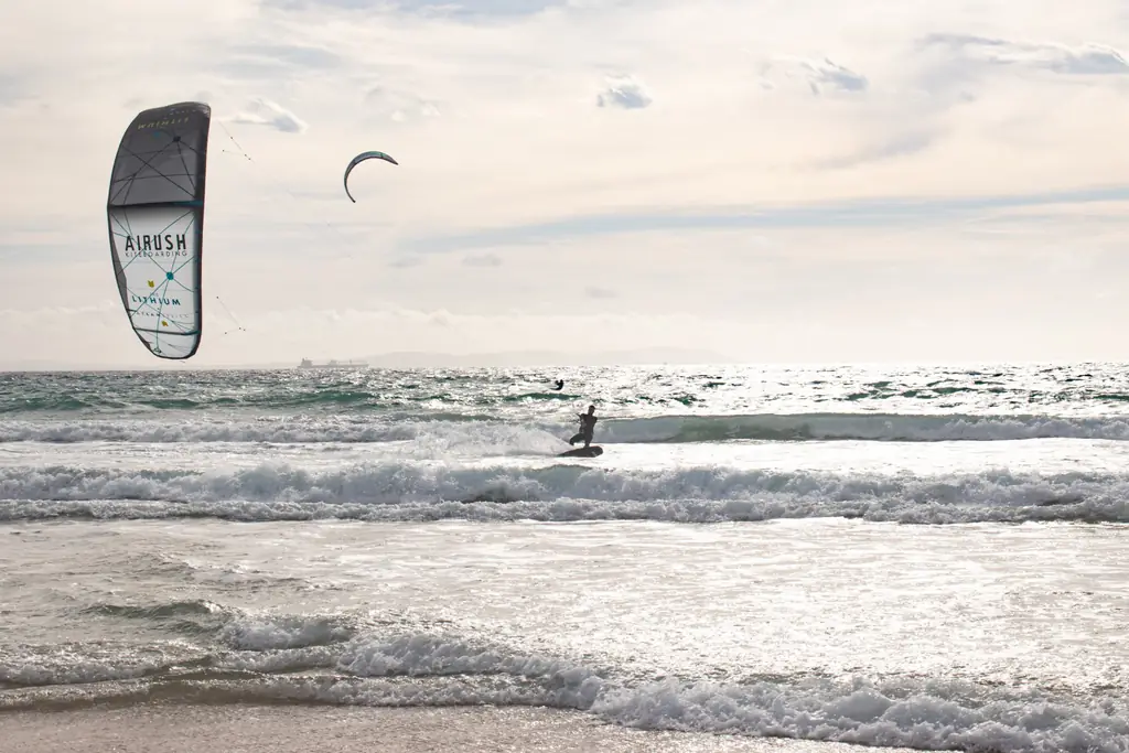 Kitesurfista surfeando una ola frente a la costa de Tarifa