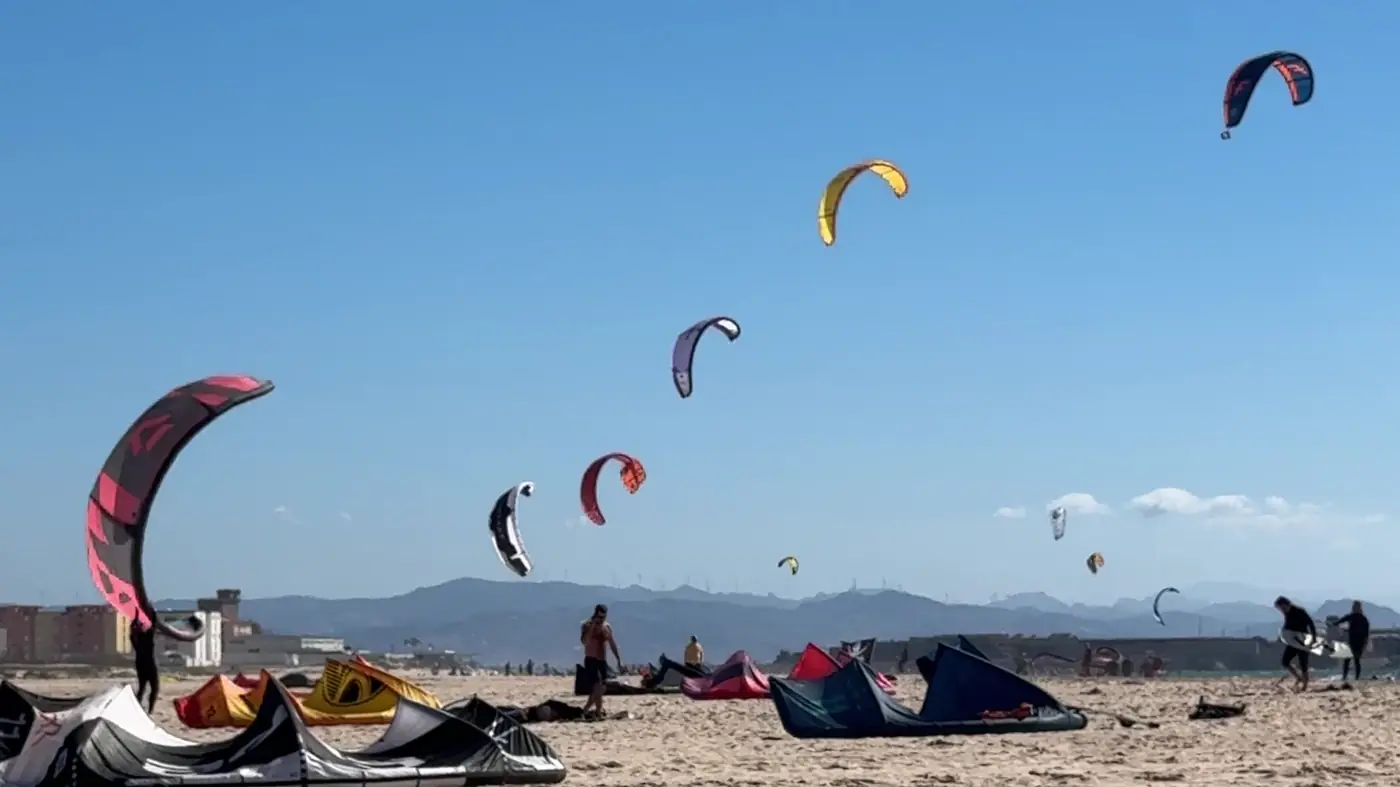 Muchas cometas en el cielo sobre la playa de Tarifa, delante cometas en la arena